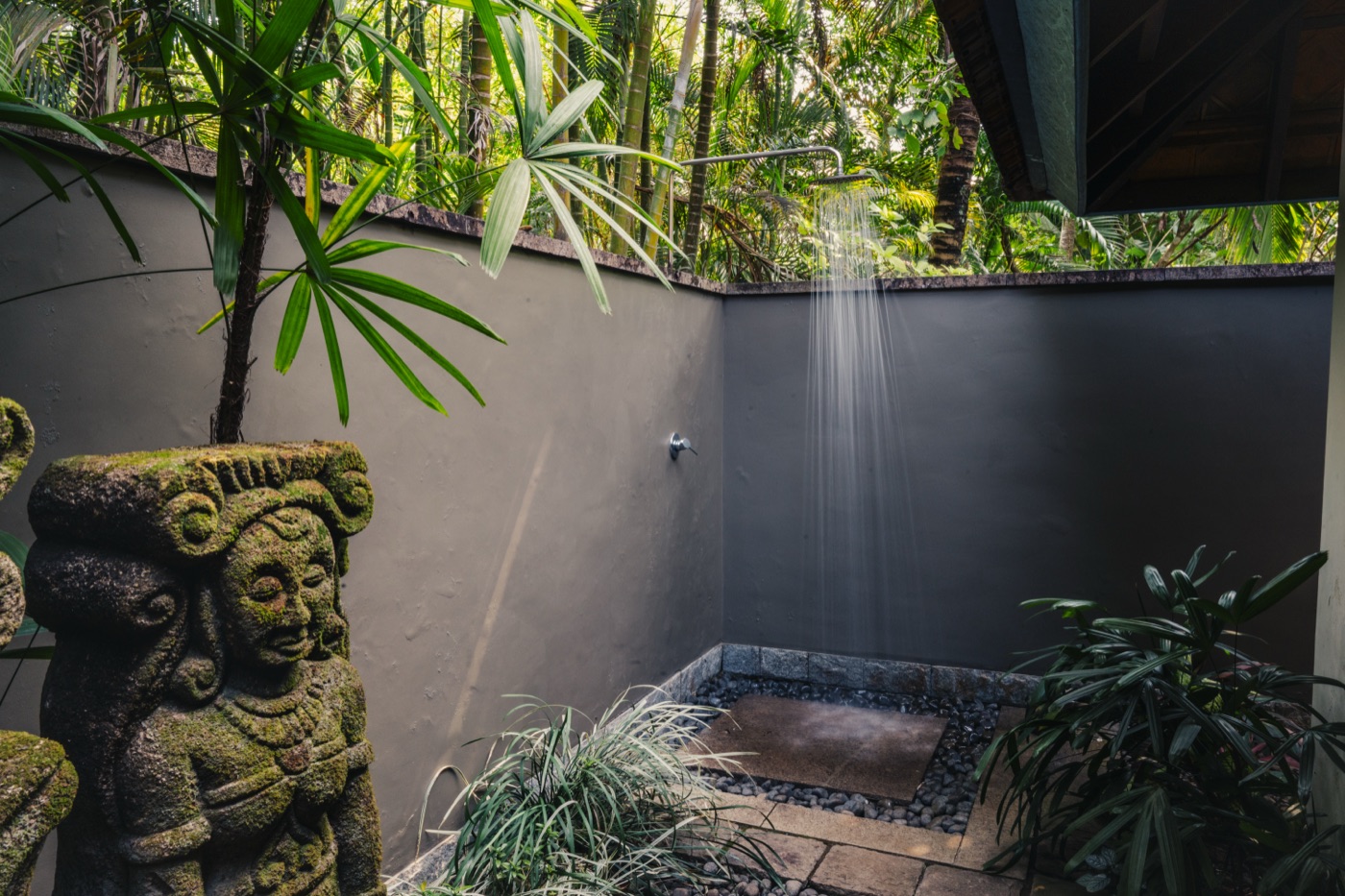 Open-air garden shower walled in palms