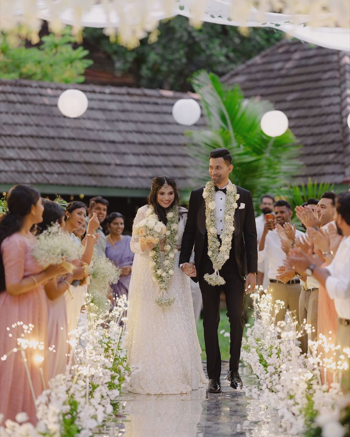 A bride and groom walk a sparkler-lined aisle at a wedding at Indian Summer House