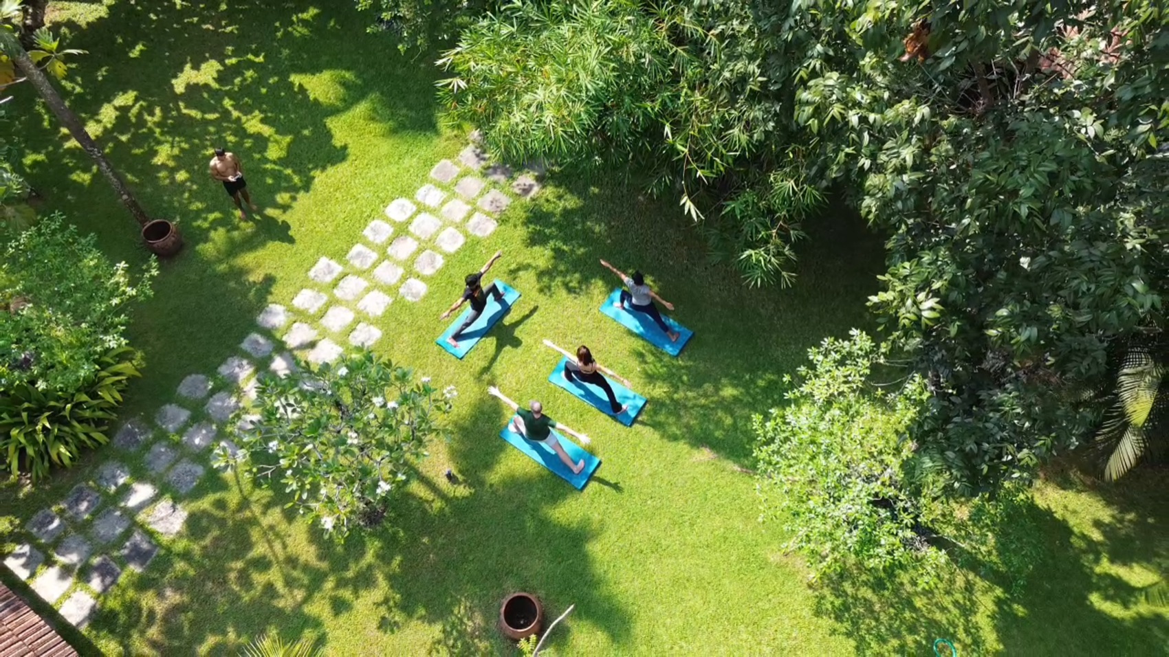 Guests in a morning yoga class on the garden lawn